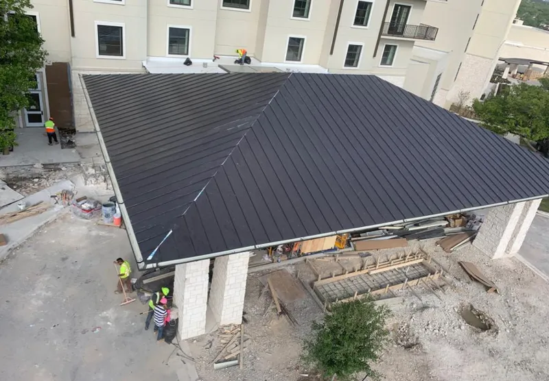 Metal roofing installation team working on a commercial building in Lower